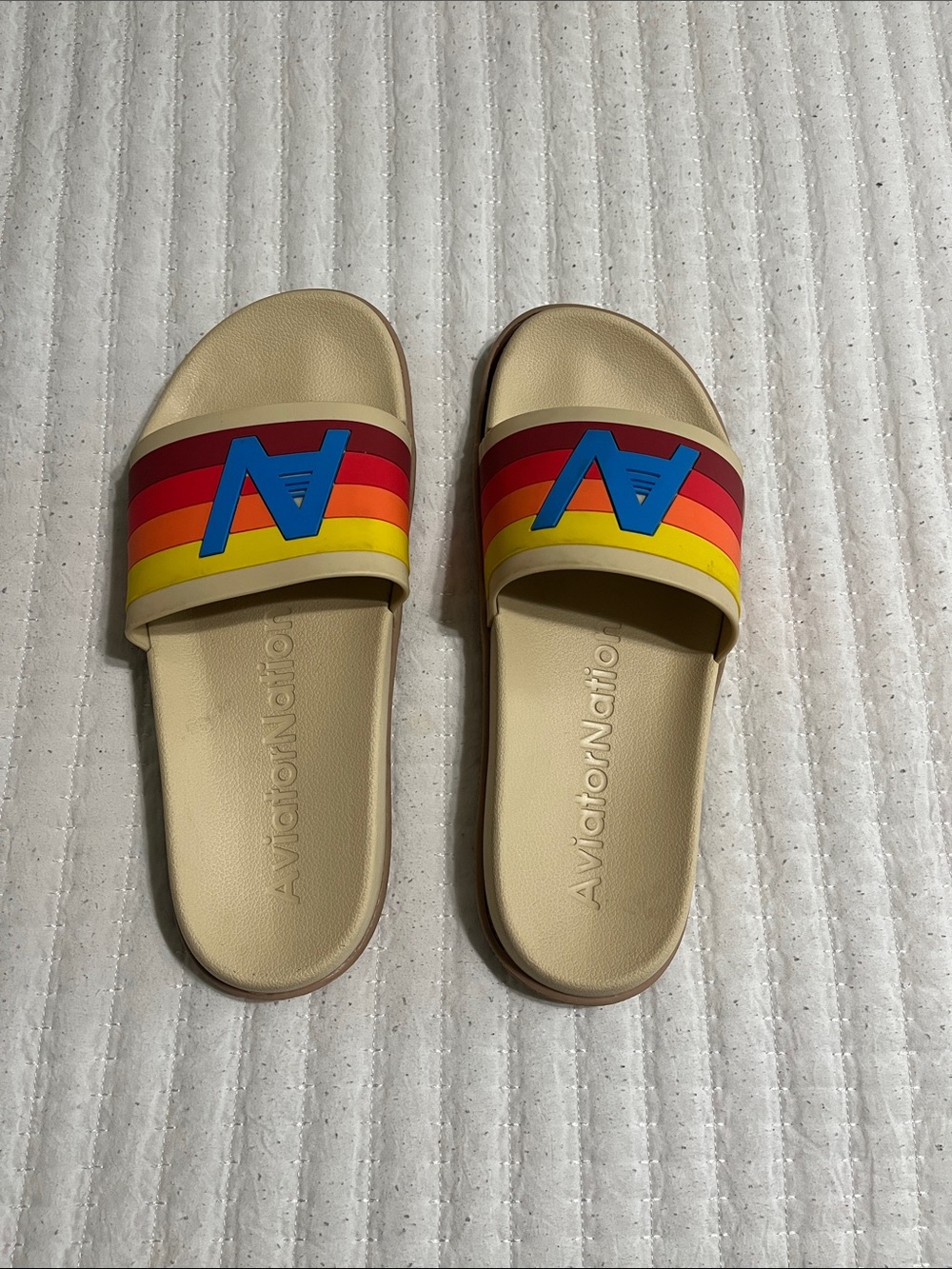 Aviator Nation Beige Slide Sandals with Rainbow Stripes and Blue Logo